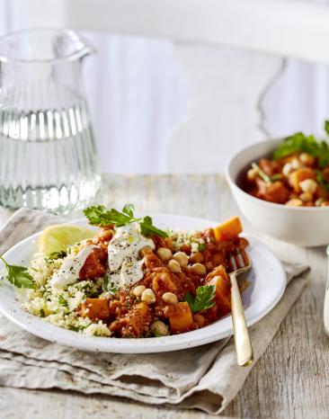 Gulasch mit Süßkartoffel und Couscous auf einem Teller.