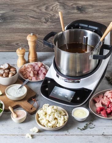 Fleisch-Fondue im Cookit mit Beilagen drum herum.