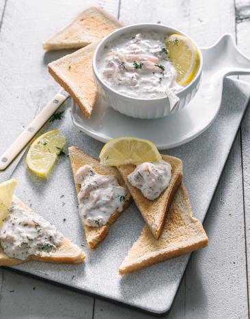 Heller Dip mit mit Crackern und Toast auf einem Tablett.