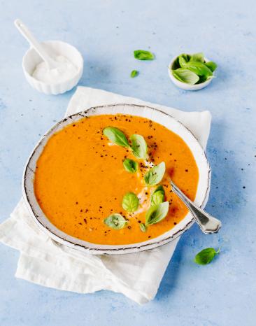 Teller mit Suppe und Basilikum