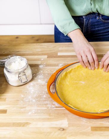 Teigrand wird an Tartin-Form gedrückt