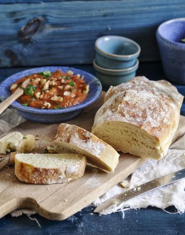 Ciabatta mit würziger Sauce auf einem Brett.