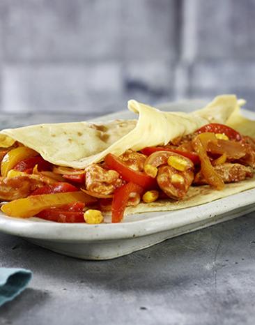 Fajitas mit saftigem Hähnchenfleisch, buntem Gemüse und selbstgemachten Tortillas.