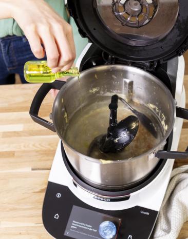 Spülmittel wird in den Cookit Topf gegeben.