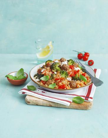 Reistopf mit Hackbällchen auf einem Teller, dekoriert mit einem Stofftuch