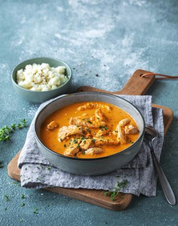 Schale Blumenkohlreis und Schale mit Putengulasch in roter Sauce