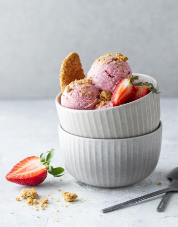 Strawberry-Cheesecake-Eis zu Kugeln portioniert in einer Schüssel.