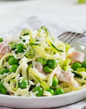 Zucchininudeln mit Schinken-Sahne-Soße auf einem Teller angerichtet