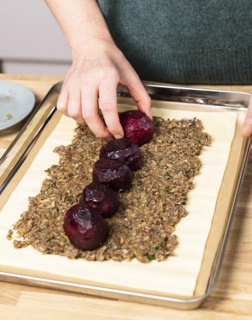 Rote Bete wird auf die Duxelles-Füllung für Beet Wellington gesetzt