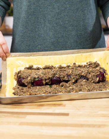 Der Blätterteig wird um die Füllung des Beet Wellington gelegt