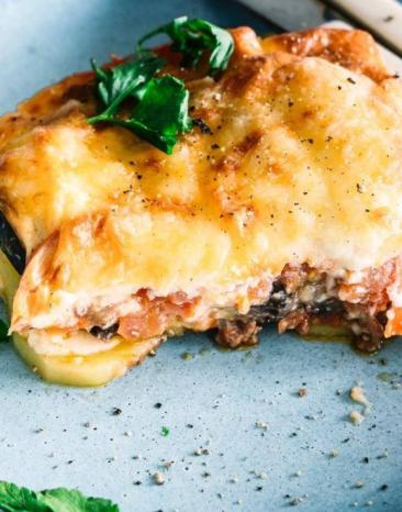 Griechische Moussaka auf einem Teller garniert mit Petersilie