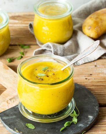 Cremige Kartoffelsuppe in Gläsern mit Kräutern garniert.