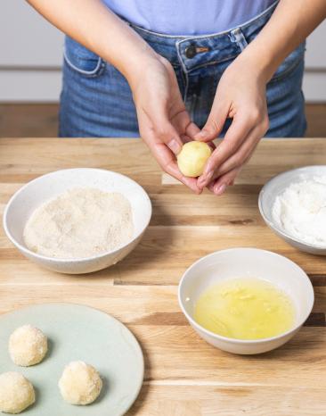 Krokettenteig wird zu Bällchen geformt. Krokettenteig wird zu Bällchen geformt.
