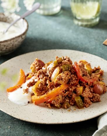 Arabisches Reiterfleisch mit Paprikastreifen auf einem hellen Teller angerichtet.