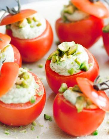 Kirschtomaten mit Basilikumcreme arrangiert auf einem weißen runden Teller