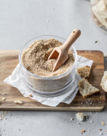 Paniermehl im Glas auf einem Holzbrett