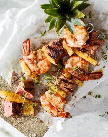 Surf-and-Turf-Grillspieße mit Sous-vide Rumpsteak auf einem mit Backpapier ausgelegten Brettchen