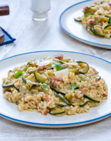 Risotto mit Zucchini und Speck auf einem Teller