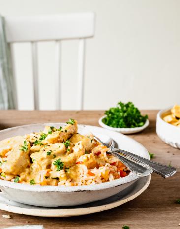 Hähnchen mit Gemüsereis auf einem gedeckten Tisch