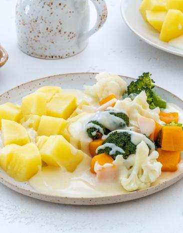 Kartoffeln mit buntem Gemüse und Käsesauce.