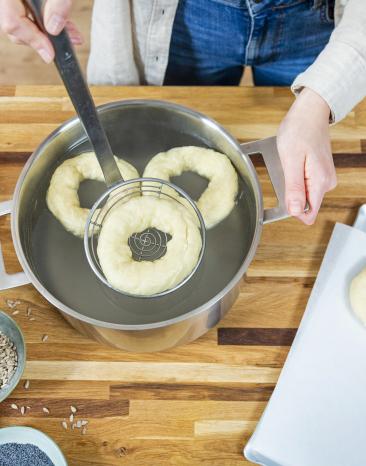 Bagels werden in heißem Wasser gegart.