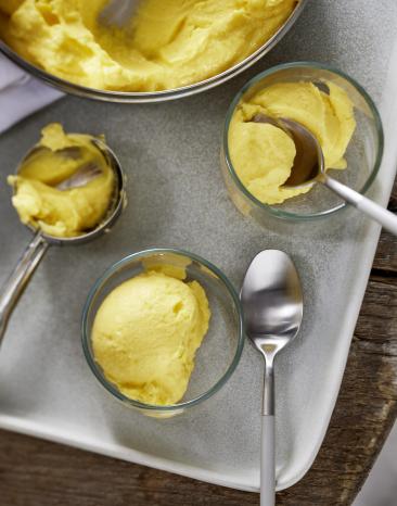 Schnelles Mango-Eis wird Kugelweise portioniert serviert.