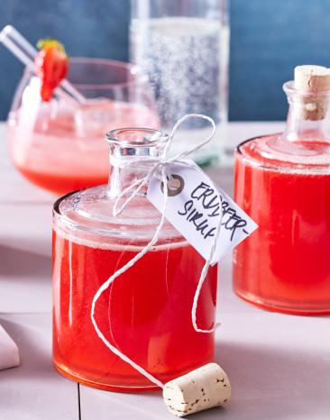 Erdbeer Sirup abgefüllt in kleinen Glasflaschen.