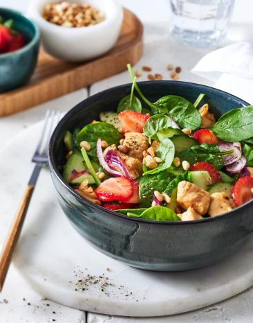Erdbeer-Spinatsalat mit Hähnchen in einer Schüssel angerichtet.