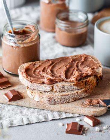 Zartschmelzende Milch-Schoko-Creme auf einer Scheibe Brot.