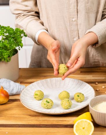 Falafelmasse mit den Händen zu kleinen Bällchen formen.