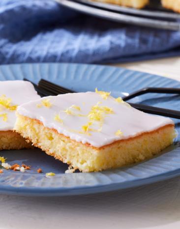 Zitronenkuchen vom Blech in Stücke geschnitten.