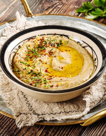 Baba Ghanoush in einer Schale mit Olivenöl und Gewürzen serviert.