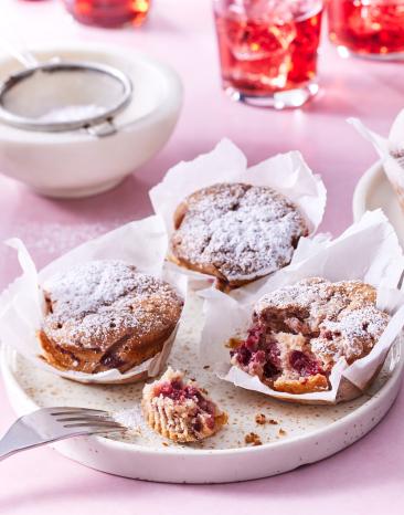 Kirschmuffins auf einem rosafarbenen Untergrund.
