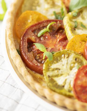 Tomaten Tarte mit Basilikum in einer Form.