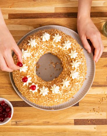 Frankfurter Kranz wird mit Belegkirsche dekoriert.