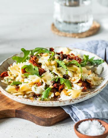 Mediterraner Nudelsalat auf einem Teller mit Kräuterdressing