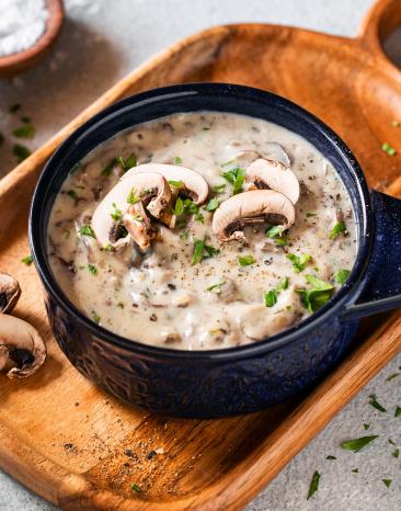 Pilzrahmsauce in einer kleinen Schüssel mit Champignons getoppt.