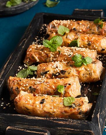 Thai-Frühlingsrollen mit Reispapier und Kräutern getoppt.