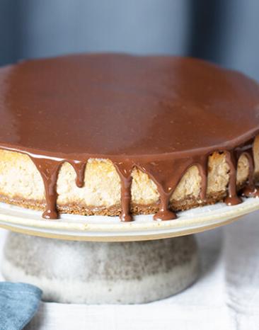 Veganer Käsekuchen getoppt mit Schokoladensauce.