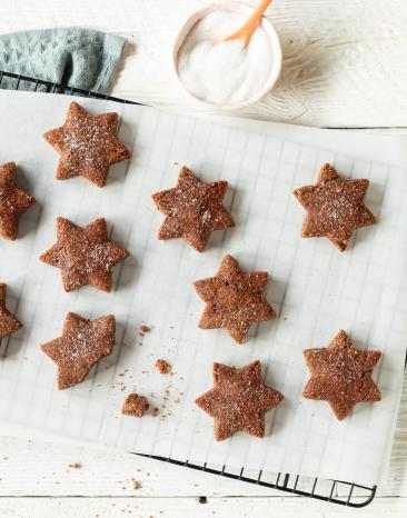 Basler Brunsli in Sternform nebeneinander auf einem Kuchengitter.