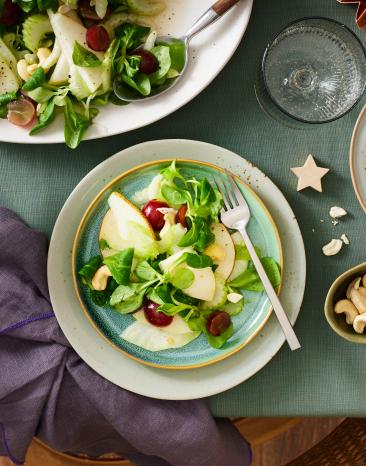 Wintersalat mit Birne in einer Schüssel und aufgetischt.