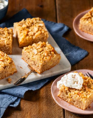 Apfelkuchen vom Blech in Stücken auf Servierplatte und Teller