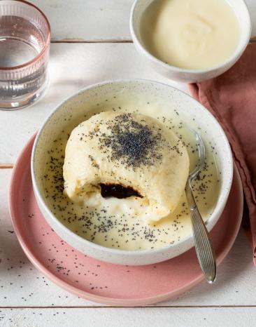 Germknödel mit Vanillesauce in tiefem Teller