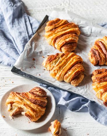 Franzbrötchen mit Zimt auf einem Backblech.