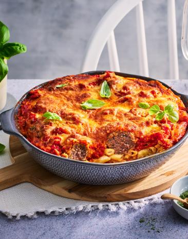 Hackbällchenauflauf mit Nudeln, mit Käse überbacken in einer runden Auflaufform.