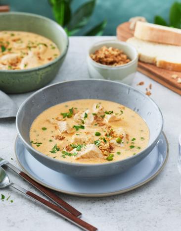 Pute in Senfsauve in zwei Schüsseln mit Kräutern dekoriert.