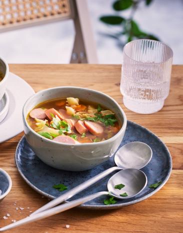 Gemüsesuppe mit Nudeln in Suppenschüsseln auf einem Tisch.