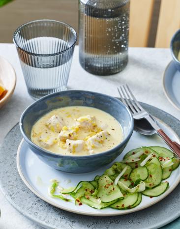 Hähnchen in Orangensauce auf einem Teller mit Gurkensalat.