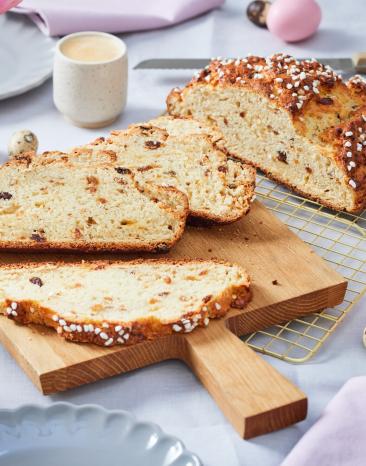 Osterbrot auf einem gedeckten Tisch mit Tulpen.