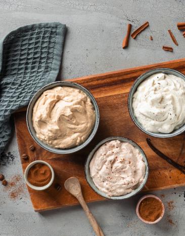 Schlagsahne in vier verschiedenen Geschmacksrichtungen in Schälchen.